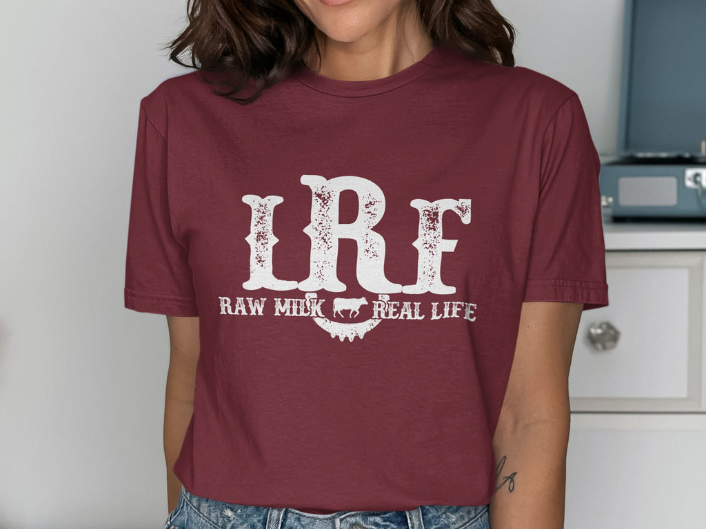 Maroon t-shirt with white distressed text "IRF RAW MILK REAL LIFE" and cow graphic.