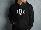 A person wearing a black hooded sweatshirt with a distressed white RRF logo and text.