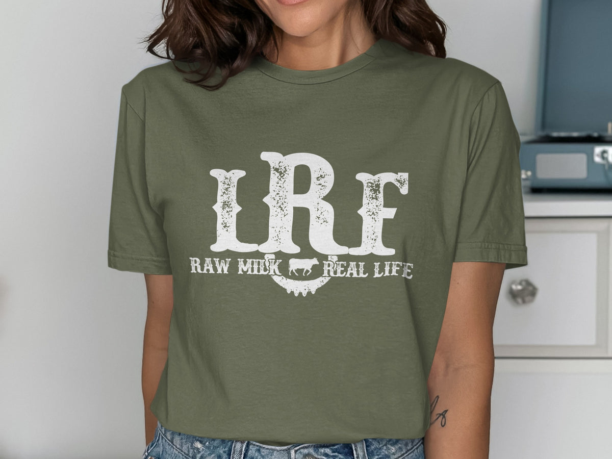 Green t-shirt with distressed white text "LRF RAW MILK REAL LIFE" and a cow silhouette.